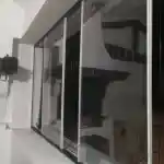 Les moments clés de l’aménagement de la chatterie | Montre la fenêtre de type tropézienne de la chatterie réservée à mes chats, surmontée d’une protection en panneau rigide en acier galvanisé plastifié et d’une ouverture coulissante.